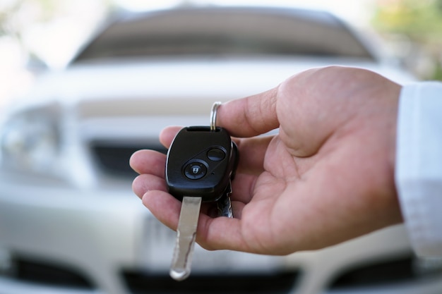 El propietario del vehículo está de pie las llaves del coche al comprador.