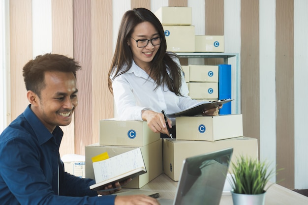 Foto propietarios de empresas pyme controlando pedidos y preparando cajas de productos.