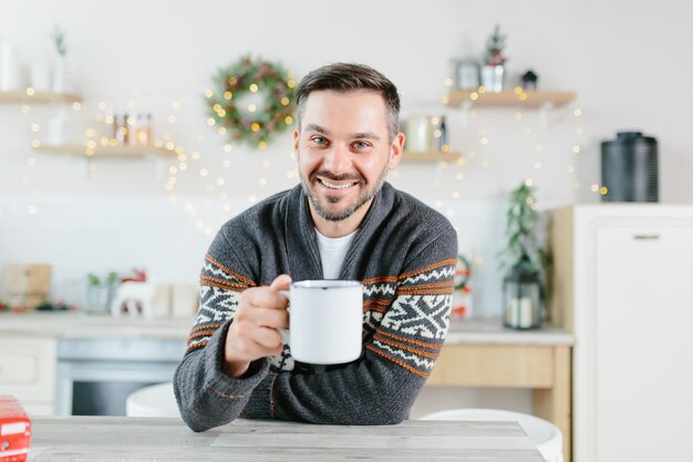 El propio hombre en casa mira a la cámara y se comunica a través de un enlace de video, ve desde la cámara web, saluda a amigos y colegas con las vacaciones de Navidad y Año Nuevo.