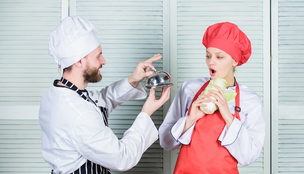 Proposta deliciosa. Chef de homem oferece sobremesa ou refeição sob cloche para menina. Você vai comer minha refeição. Família culinária. Mulher e homem barbudo cozinhando juntos. Cozinhando refeição exclusiva. Junte-se ao estilo de vida gourmet.