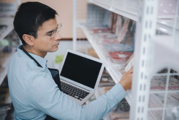 Proprietário de empresa masculina verificando a venda de produtos na prateleira