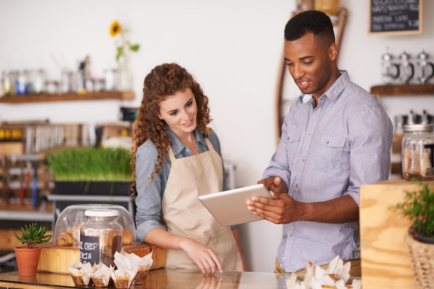 Foto proprietário de tablet café e trabalho em equipe de pessoas conversando, discutindo e gerenciando pedidos garçons, homem e mulher negros em restaurante com tecnologia para verificação de estoque de estoque e gerenciamento de vendas na loja