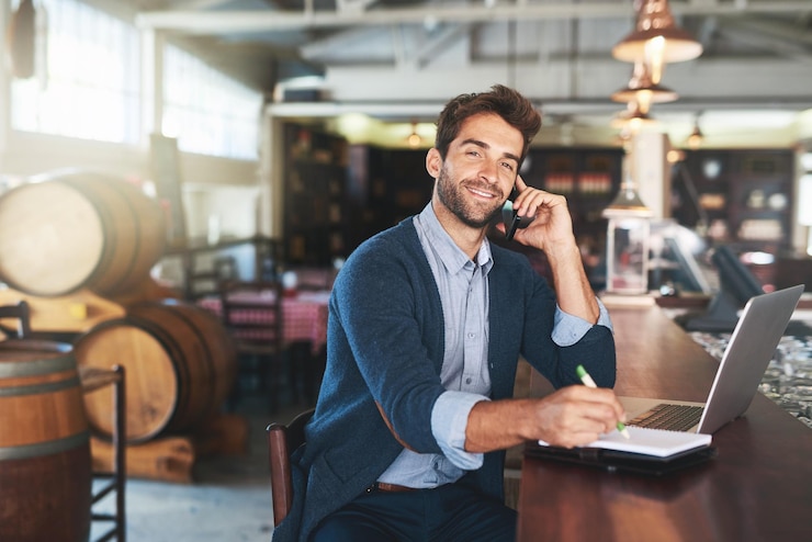Foto proprietário de um restaurante e retrato de um homem com uma chamada telefónica para planear a comunicação ou a informação pessoa masculina pub e caderno com tecnologia para atualização de estoque de inventário ou feedback do fornecedor