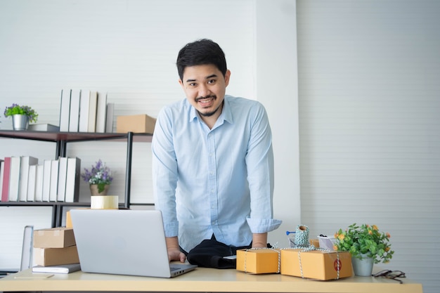 Foto proprietário de uma empresa do oriente médio está no escritório com caixas de embalagem de produtos para entrega