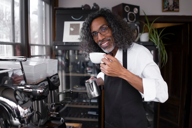 Foto proprietário sorridente de tiro médio com xícara de café