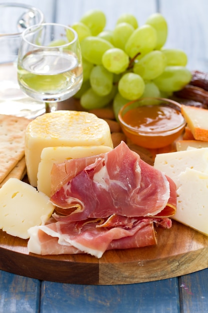 Prosciutto mit Käse und Weißwein im hölzernen Brett