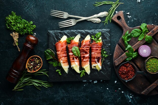 Prosciutto mit Melone auf einer Steinplatte Traditionelle italienische Vorspeise Draufsicht Kostenloser Kopierbereich