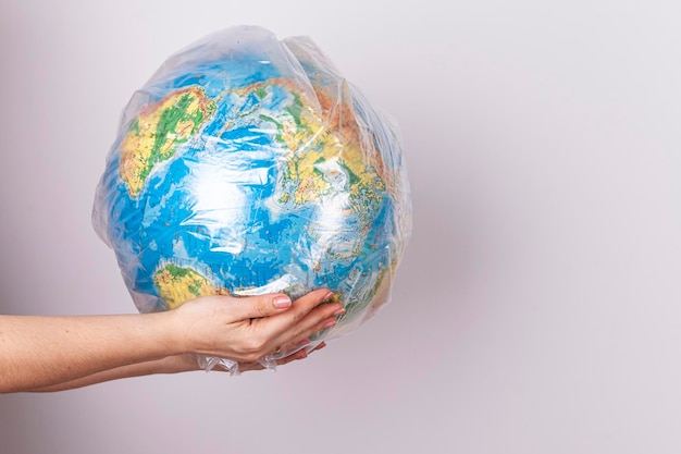 Foto proteção ambiental manchando o planeta uma mulher segura em suas mãos o planeta terra nas fo