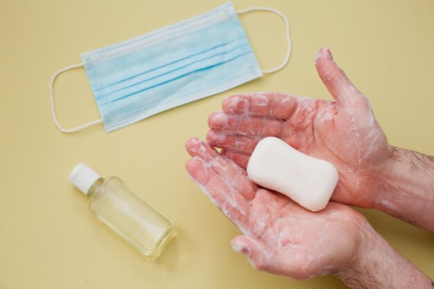 Proteção durante o conceito de surto de vírus limpando as mãos masculinas com uma barra de sabão