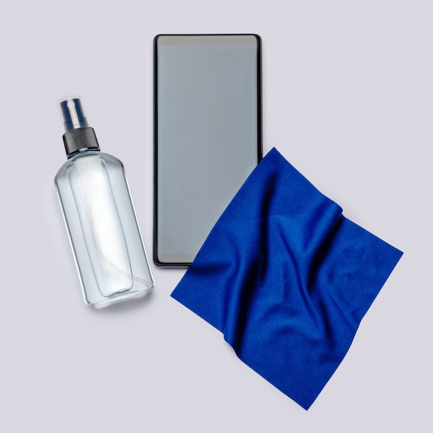 Proteção ou saneamento contra vírus ou germes - limpeza ou desinfecção do telefone celular com spray e pano anti-séptico desinfetante