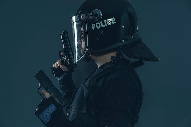 Proteção, polícia de choque sinalizando para colegas com as mãos. homem armado com capacete e colete à prova de balas