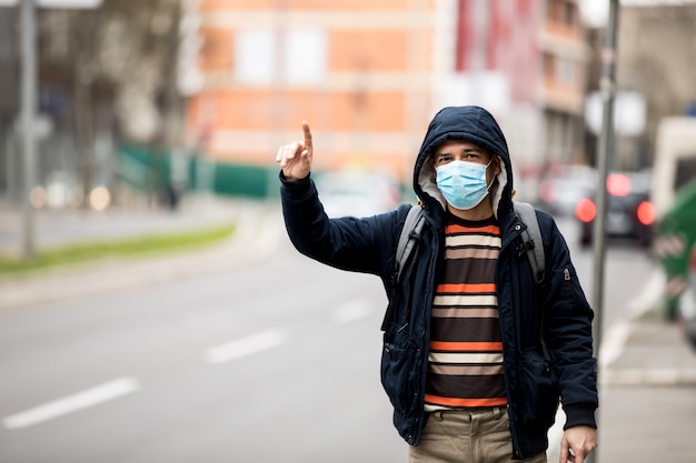 Protección contra el coronavirus. Hombre maduro en la ciudad después de la jornada laboral, con una máscara protectora en la cara.