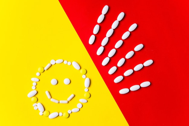 Protección contra la enfermedad. Pastillas, tabletas y cápsulas de colores en la pared roja y amarilla: antecedentes del tratamiento. Concepto de salud y medicina, vacuna, prevención de pandemias, epidemias.