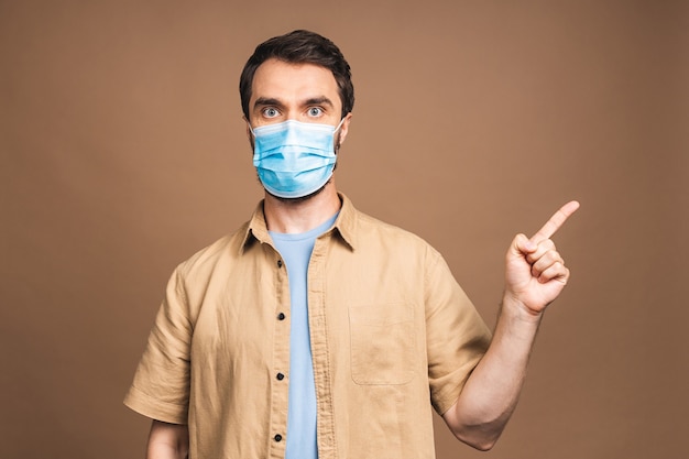 Protección contra enfermedades contagiosas, coronavirus, covid-19. Hombre con máscara higiénica para prevenir infecciones, enfermedades respiratorias transmitidas por el aire como la gripe, 2019-nCoV. Aislado sobre fondo beige