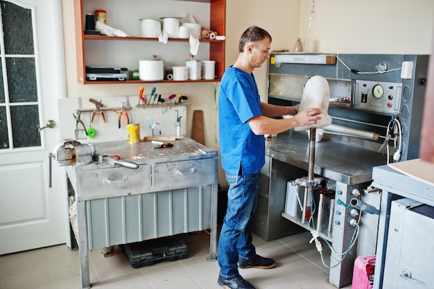 Protésico hombre haciendo pierna protésica mientras trabaja en laboratorio