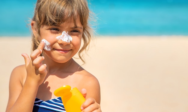 Protetor solar na pele de uma criança. Foco seletivo. natureza.