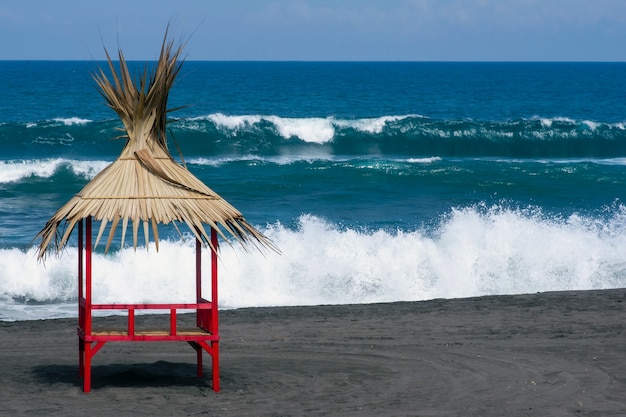 Protetores solares de praia tradicionais, foco selecionado em Pantai Dewa Ruci Purworejo, Indonésia, com o azul turvo do Oceano Índico ao fundo