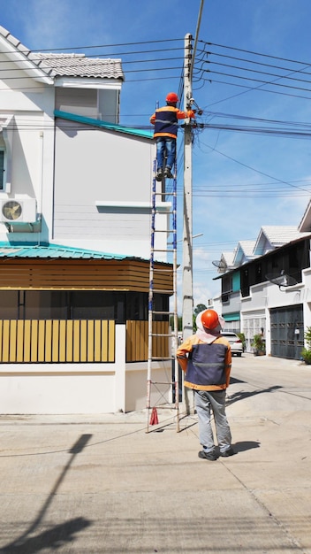 El proveedor técnico de servicios de Internet está revisando los cables de fibra óptica después de instalarlos en un poste eléctrico