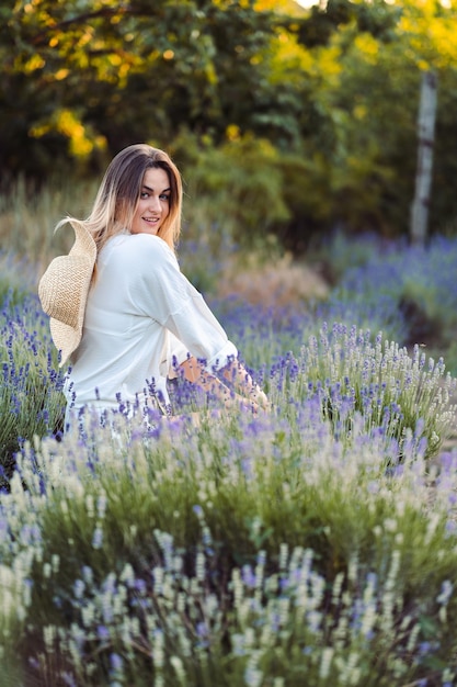 Provenza una niña sentada y sonriente en un campo de lavanda en primer plano