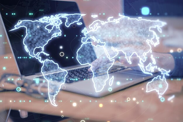 Proyección holográfica de un mapa digital del mundo sobre un teclado de portátil en un entorno oscuro que simboliza la conectividad y la tecnología globales