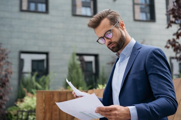 Proyecto de planificación de gerente pensativo con contrato de lectura de empresario de informe financiero