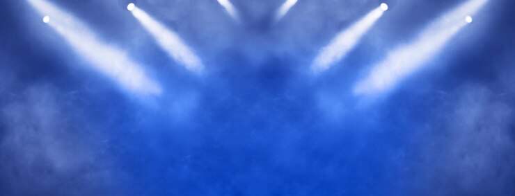 Proyector de luz de escenario y luces brillantes sobre fondo azul.