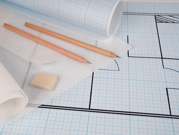 Los proyectos de casas como fondo, Arquitecto en el lugar de trabajo. Proyecto arquitectónico, planos, rollos de planos en la mesa de escritorio de madera. Fondo de construcción Herramientas de ingeniería. Copia espacio