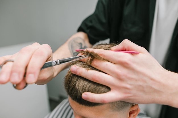 Prozess der Schere im Friseursalon Hintergrund Barber schneidet einen blonden Kunden mit einer Schere Kopieren Sie Platz