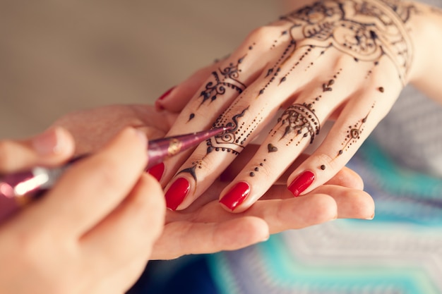 Prozess des Anwendens von mehndi auf weiblichen Händen