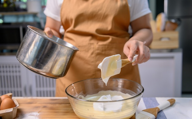 Prozess des Kochens von köstlichem hausgemachtem Kuchen und Halloween-Cupcake. Frau, die Zutaten für Süßspeisendesserts in der Küche zu Hause zubereitet und mischt.