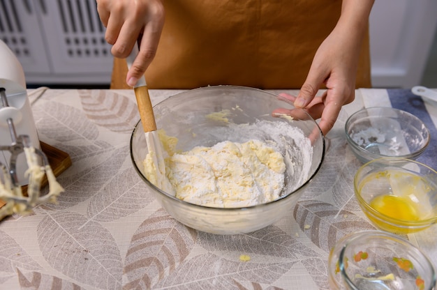 Prozess des Kochens von köstlichem hausgemachtem Kuchen und Halloween-Cupcake. Frau, die Zutaten für Süßspeisendesserts in der Küche zu Hause zubereitet und mischt.
