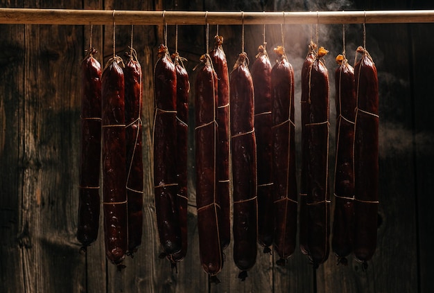 Prozess des Räucherns Wurst hängen in einem Schrank mit Rauch Rauchwolken steigen auf und umhüllen die in einer Reihe hängenden Würste