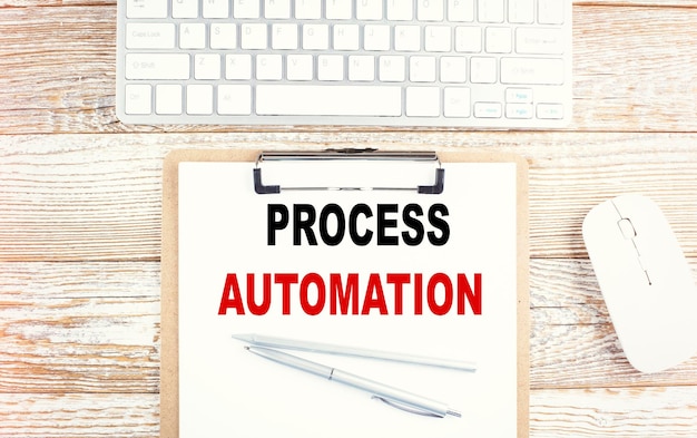 PROZESSAUTOMATISIERUNGStext in der Zwischenablage mit Tastatur auf Holzhintergrund