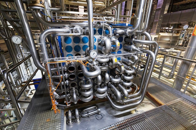 Prozesswärmetauscher an der Isolierung im Prozessbereich einer Pipeline, die rostfreie Chemikalien in einer Fabrik im Kontrollraum durchfließt