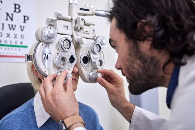 Prueba de examen ocular y paciente con médico para la visión en la consulta de optometría para lentes o monturas Mujer y hombre en atención médica con máquina para ojos con seguro médico y atención oftalmológica experta