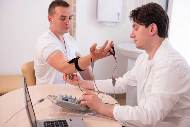 Prueba de los nervios del paciente mediante electromiografía en el centro médico