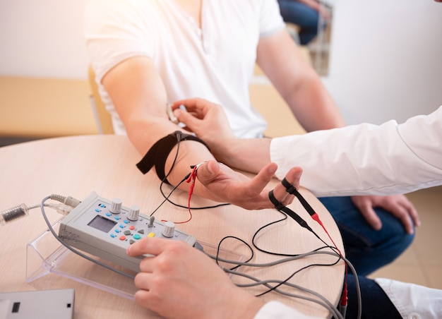 Prueba de los nervios del paciente mediante electromiografía en el centro médico