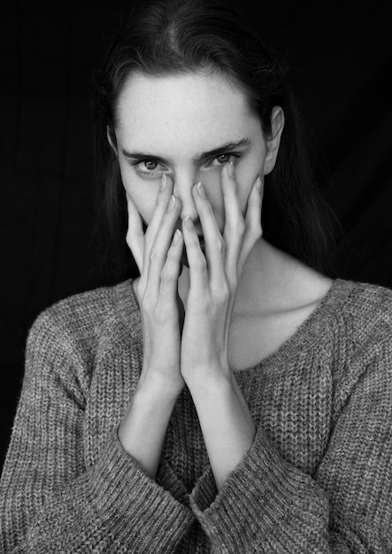 Foto prueba de retrato modelo con modelo de moda joven y bella con puente gris sobre fondo negro. retrato dramático.