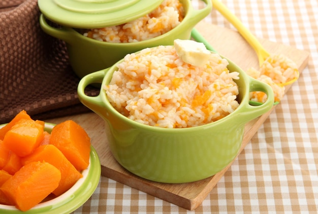 Pruebe las gachas de arroz con calabaza en cacerolas sobre fondo de mantel