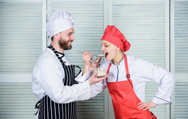 Pruebe los ingredientes antes de cocinar Estime el sabor Comida saludable Nutrición saludable Cocinar comida saludable Solo pruebe esta Deliciosa comida Mujer y hombre barbudo cocinando juntos Pareja compite en cocina