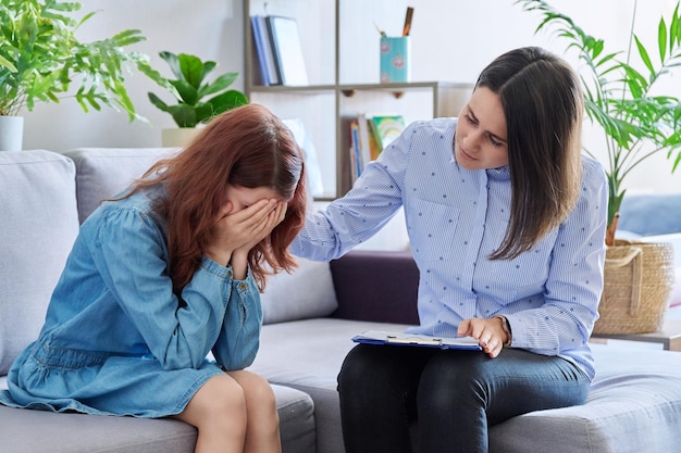 Foto psicóloga infantil profissional feminina trabalhando com meninas pré-adolescentes no escritório problemas de saúde mental infantil na escola terapia individual familiar psicologia psiquiatria dificuldades sociais infância