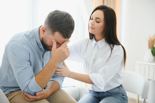 La psicóloga lleva a cabo una sesión de psicoterapia para un paciente en el consultorio de la clínica en el sofá, habla sobre sus preocupaciones y enfatiza el diagnóstico de depresión, trastorno de ansiedad, cuidando de la salud mental