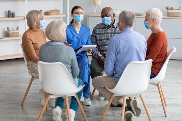 Psicóloga que tiene terapia de grupo con personas mayores