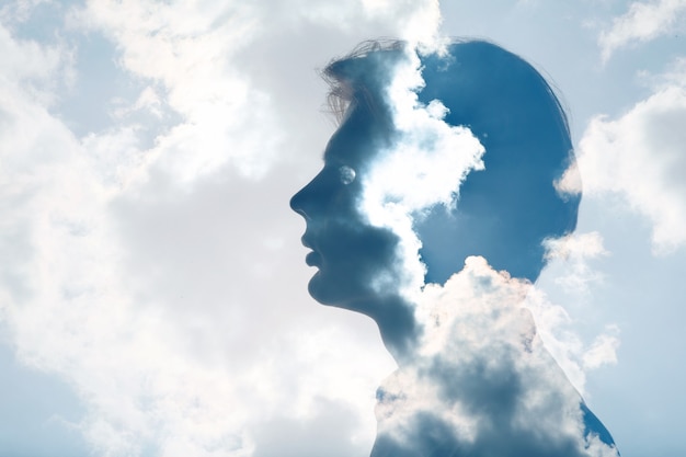 La psicología y la contemplación de la salud mental del hombre y el concepto de presión atmosférica. Nubes de exposición múltiple y sol en la silueta de la cabeza masculina.