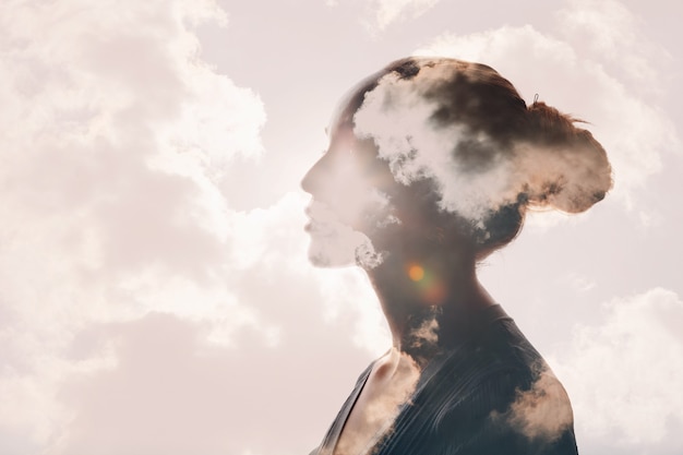 Psicología y salud mental de la mujer y concepto dependiente del clima. Nubes de exposición múltiple y sol en la silueta de la cabeza femenina.