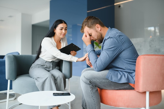 Psicología terapia mental y concepto de personas psicóloga hablando con un paciente joven triste en una sesión de psicoterapia