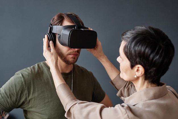 Psicólogo colocando auriculares de realidad virtual en el soldado