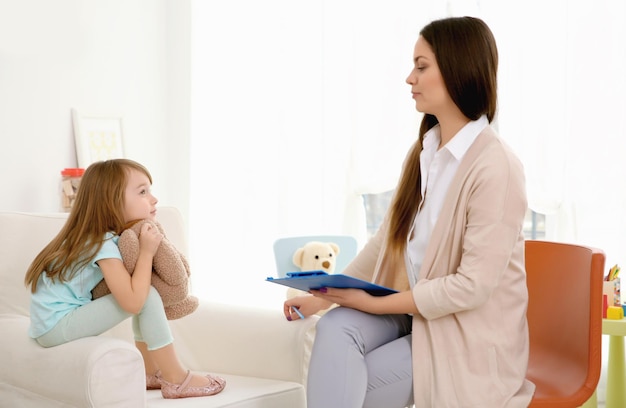 Psicólogo infantil joven que trabaja con niña