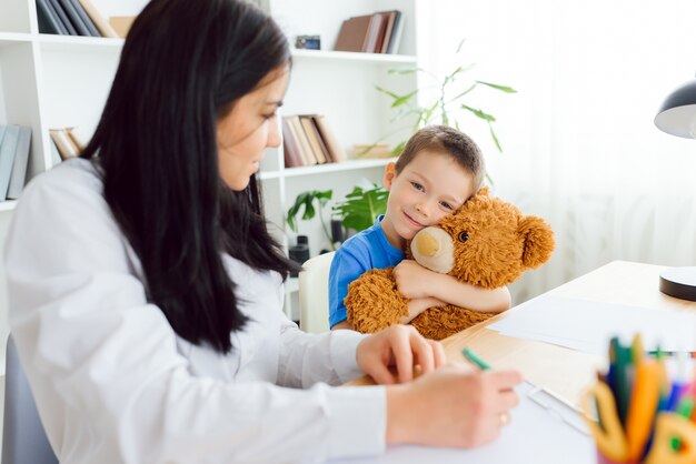 Psicólogo infantil que asiste a un niño pequeño