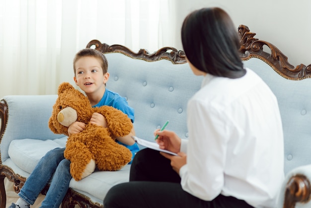 Psicólogo infantil que asiste a un niño pequeño